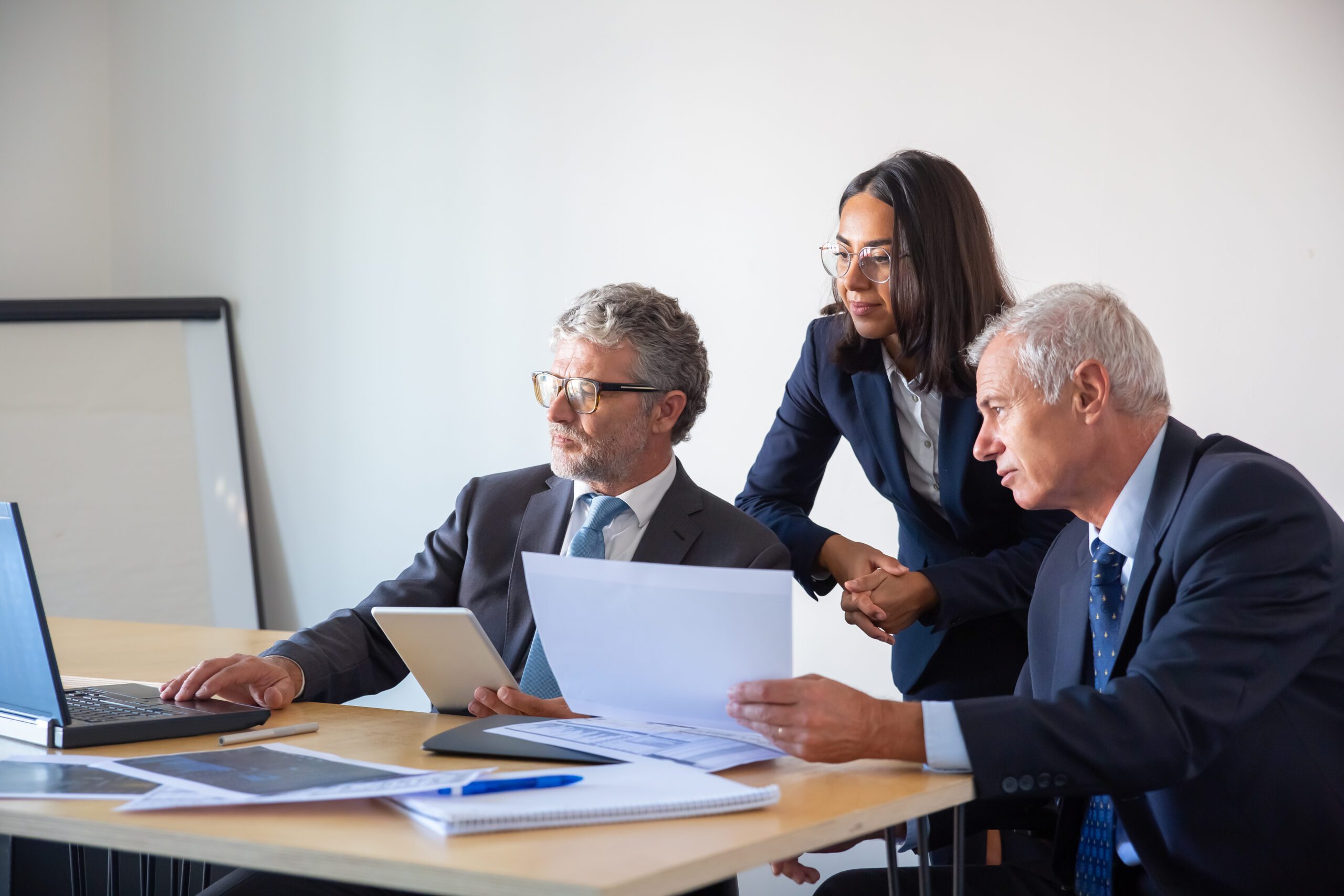 Profissionais analisando documentos e informações empresariais